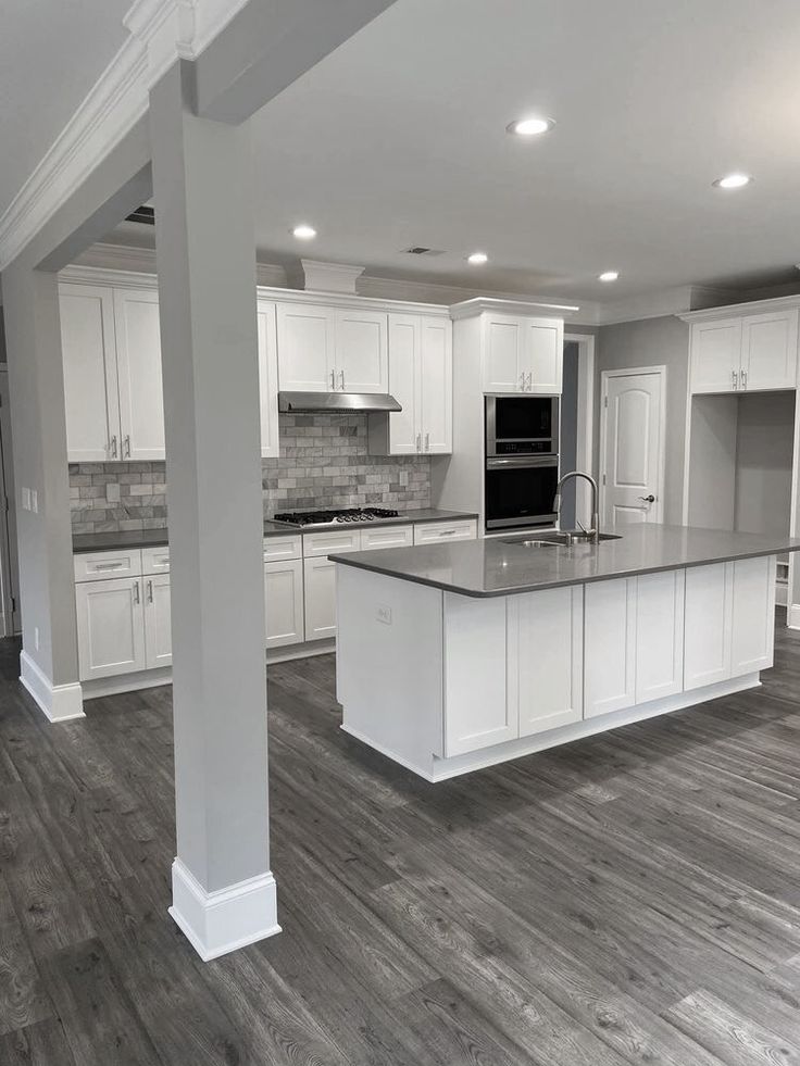 Renovated kitchen with white oak cabinetry and charcoal island in an Etobicoke condo